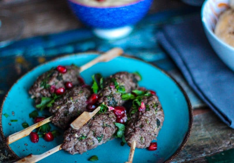 meat kabobs on a blue plate and other blue kitchen table dishware