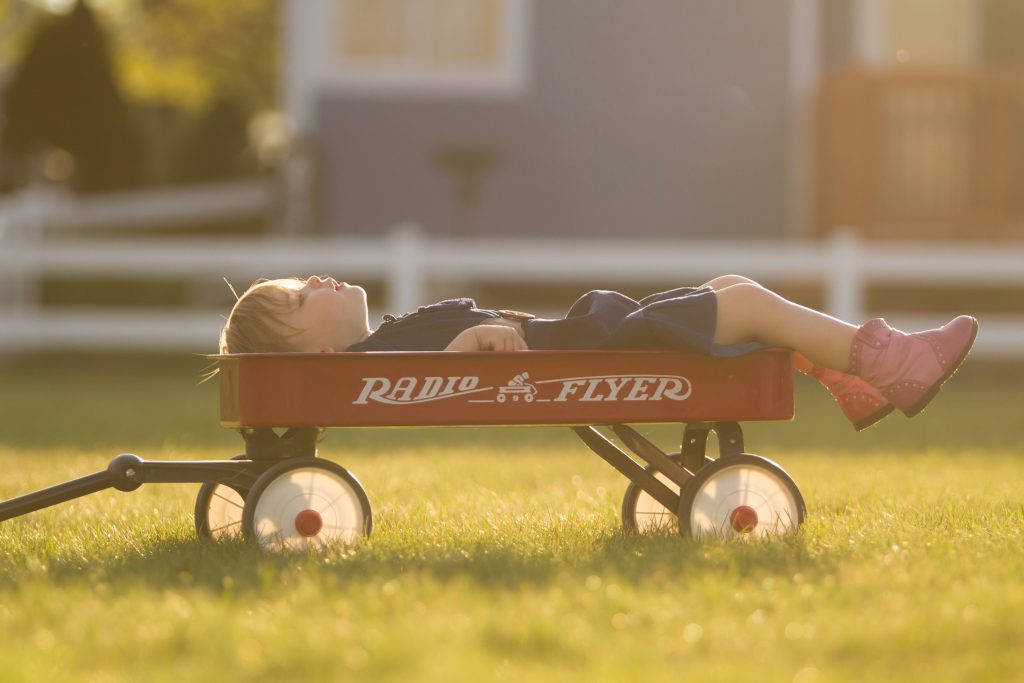 Morning rituals. Girl sleeping in a red wagon in the morning. 