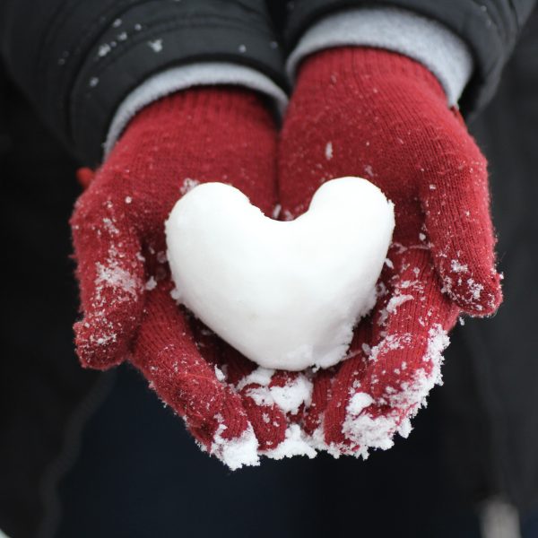 red mittens with heart made of snow