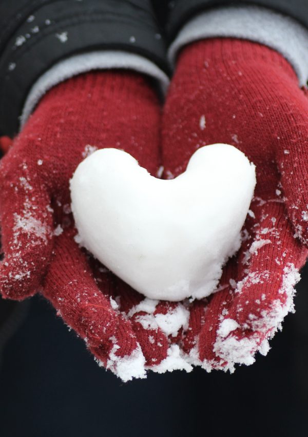 red mittens with heart made of snow