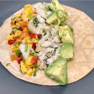 open fish taco with mango salsa and avocado on corn tortilla