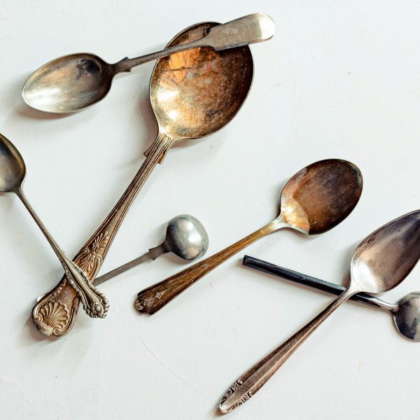 Silver and bronze spoons together on a white background