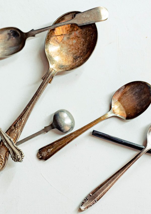 Silver and bronze spoons together on a white background