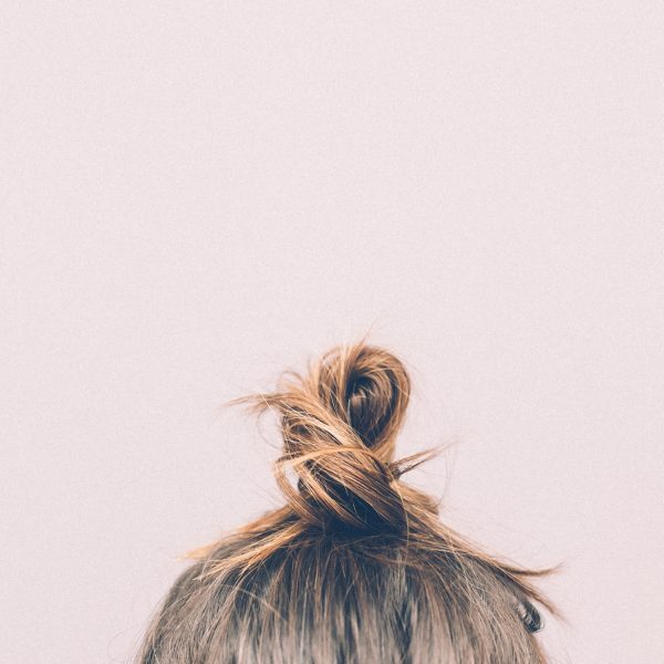 Blond hair bun on pink background