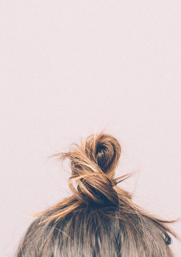 Blond hair bun on pink background